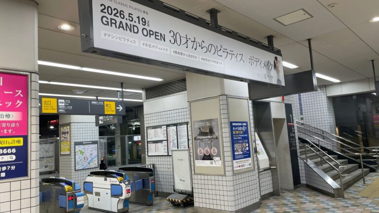 駅の改札前に掲示されたピラティススタジオの開業告知