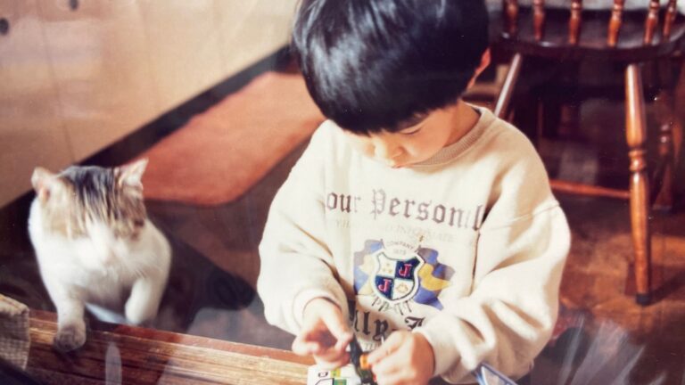 猫のそばで遊ぶ幼い子どもの写真